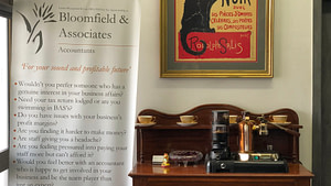 Bloomfield & Associates coffee machine on wooden cabinet with pull-up banner to the left